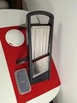 Black Mandoline Slicer With Folding Stand 2 Additional Slicing Blades. Fixed Price $19.00.